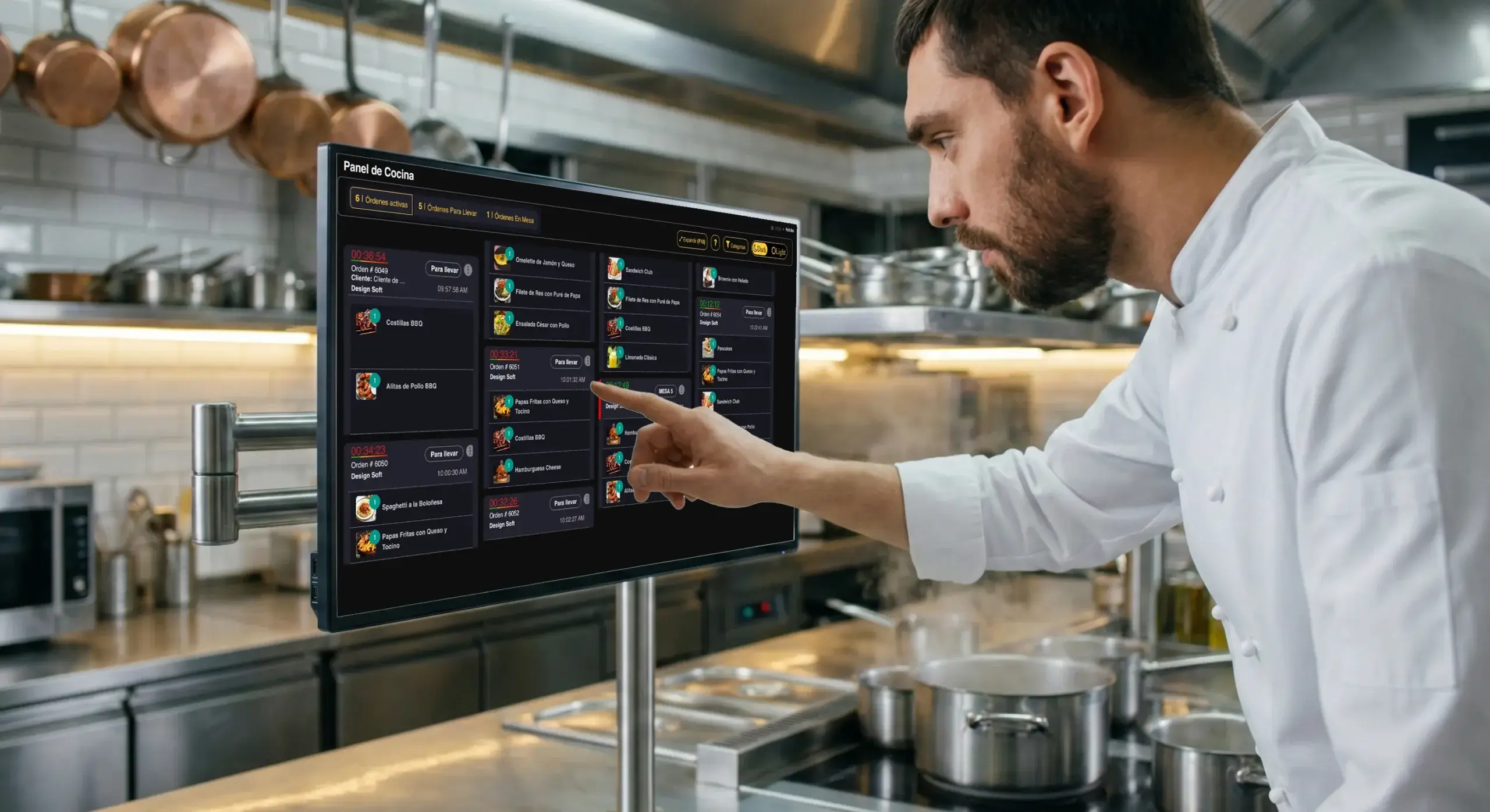 Personal de cocina utilizando el panel de comandas de POS Restaurantes en la pantalla de un restaurante